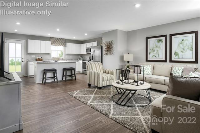 117 Hackamore Road, Unit 208 Troutman, NC 28166 - Photo 8 of 17 a living room with stainless steel appliances granite countertop furniture a fireplace a flat screen tv and a table