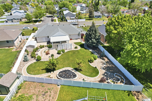 776 Flint Street Layton, UT 84041 - Photo 31 of 41 Expansive backyard featuring a manicured lawn, established landscaping, and decorative stone pathways