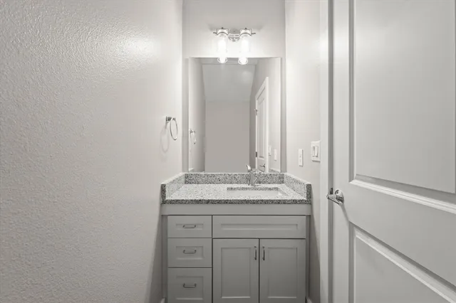 a kitchen with granite countertop a sink and a refrigerator