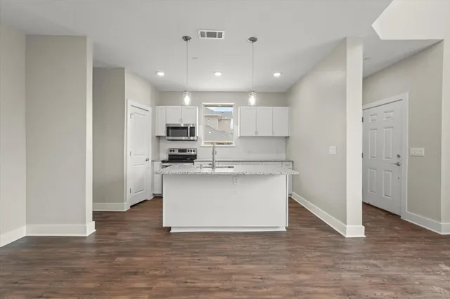 a view of kitchen view wooden floor and electronic appliances