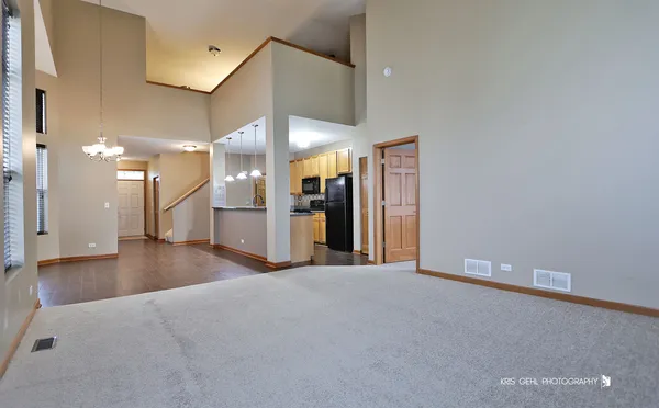 a view of a big room with entryway and kitchen view