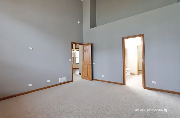 an empty room with closet and windows