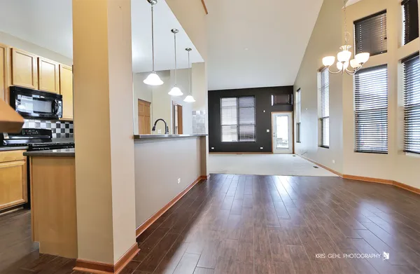 a view of a hallway with wooden floor and a living room