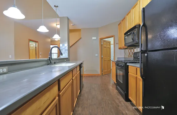 a kitchen with stainless steel appliances granite countertop a refrigerator a sink and a stove