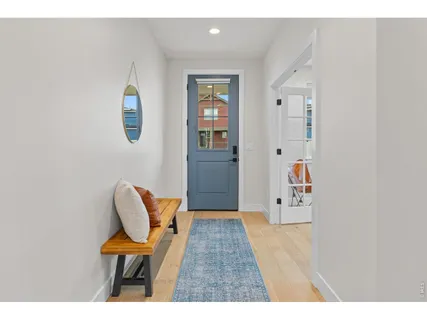 a hallway with a chair and a wooden floor