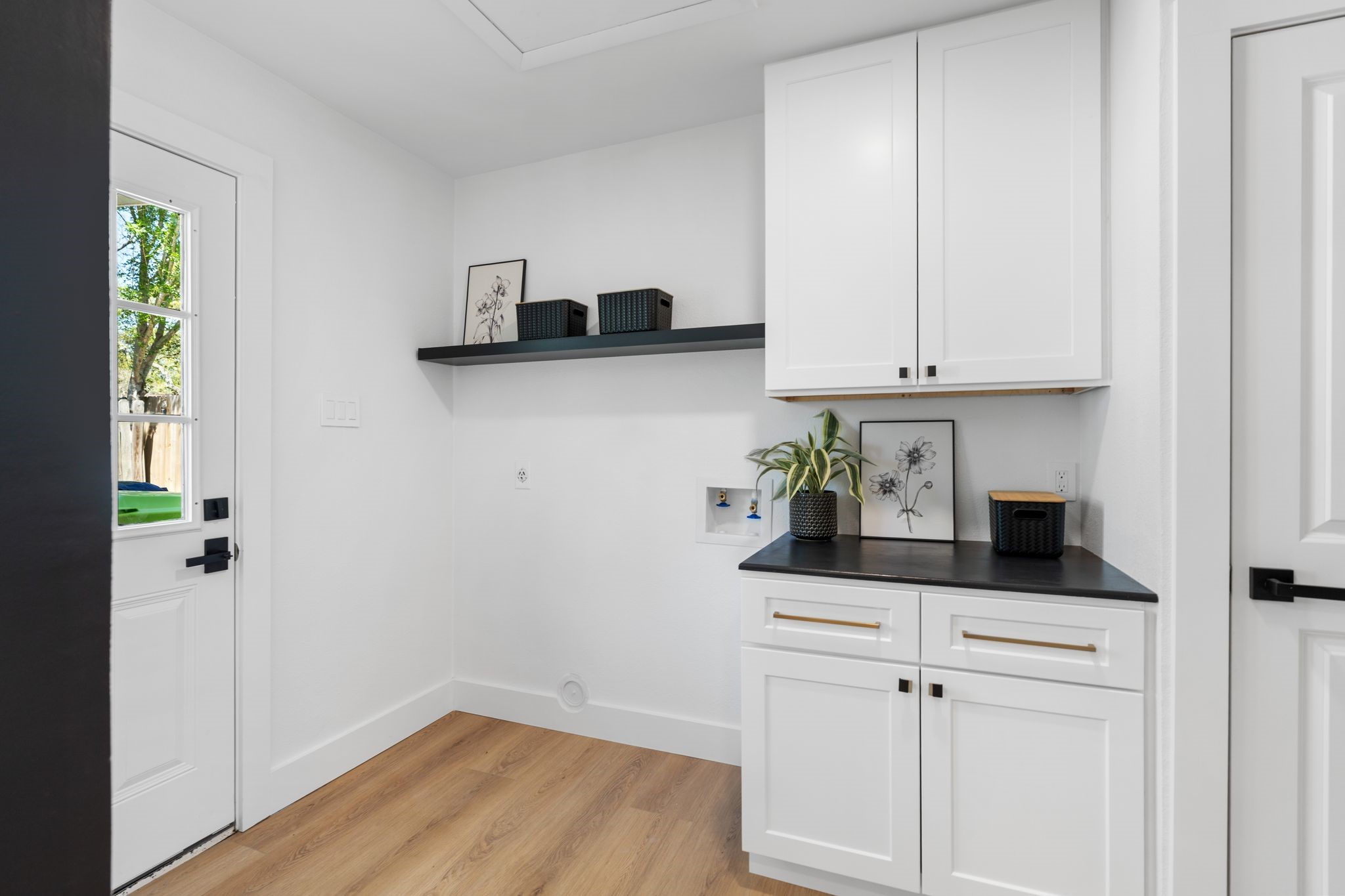 6902 Stoney River Drive Spring, TX 77379 - Photo 15 of 32 An in home laundry room with counter space, cabinets for storage and open shelving.