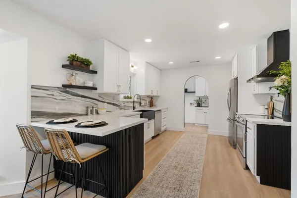 a kitchen with stainless steel appliances kitchen island granite countertop a sink and cabinets