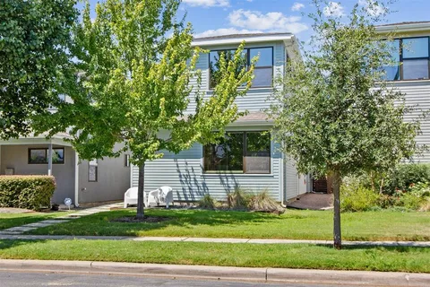 a front view of a house with a garden and trees