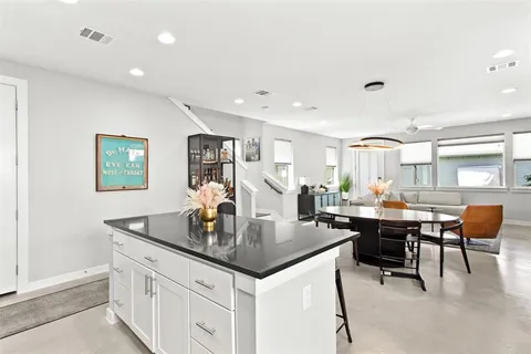 a kitchen with a dining table chairs and white cabinets
