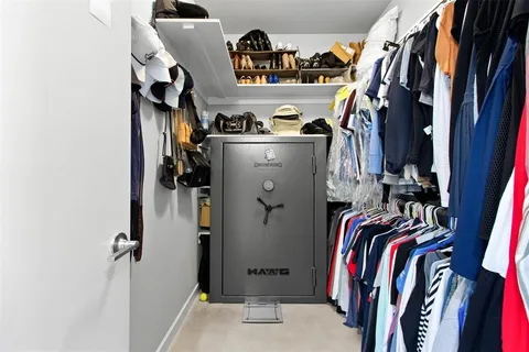 a view of walk in closet with clothes and shoes