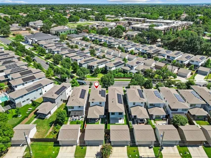 an aerial view of residential houses with yard and green space