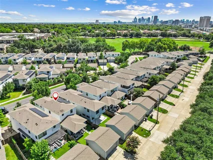 an aerial view of a city with lots of residential buildings and mountain view in back