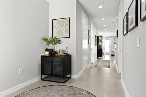 a view of a hallway with wooden floor and a potted plant