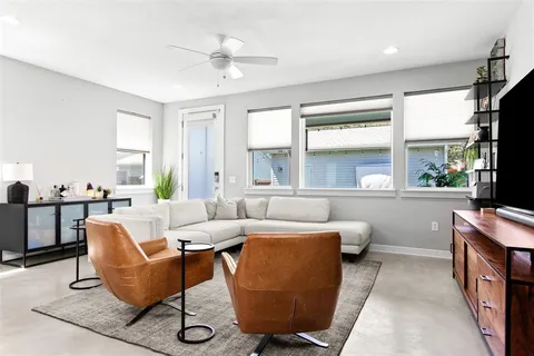 a living room with furniture a flat screen tv and a large window