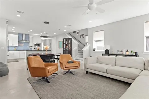 a living room with furniture and a view of kitchen