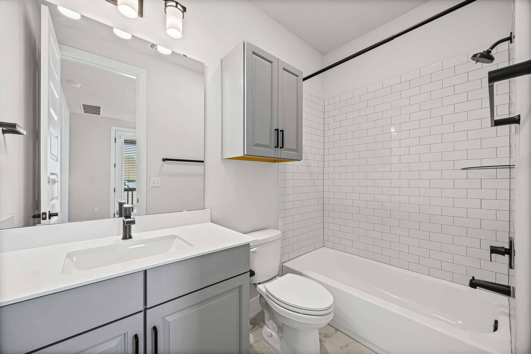 5806 Rangeland Road Austin, TX 78747 - Photo 26 of 34 Modern bath features a clean subway tile shower, sleek vanity, and sophisticated fixtures.