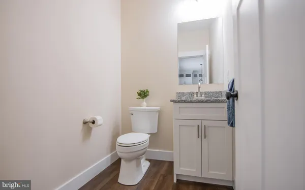 a bathroom with a granite countertop toilet sink and mirror