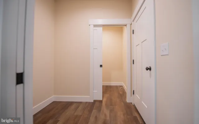 a view of a room with wooden floor and a small space