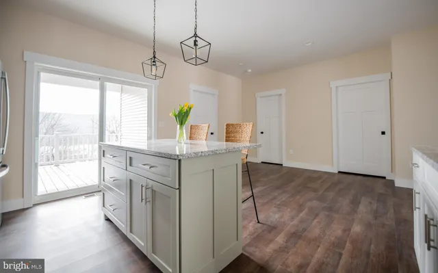 a kitchen with stainless steel appliances granite countertop a stove and a wooden floors