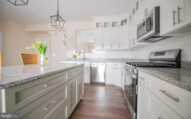 a kitchen with stainless steel appliances granite countertop a sink a stove and cabinets