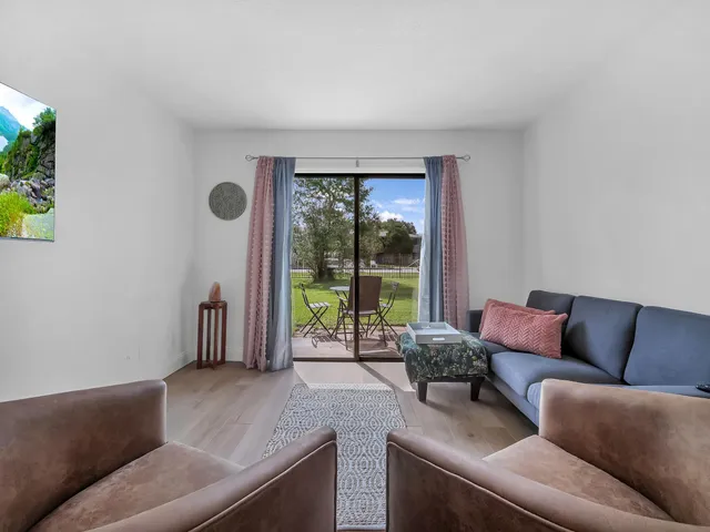 a living room with furniture and a floor to ceiling window