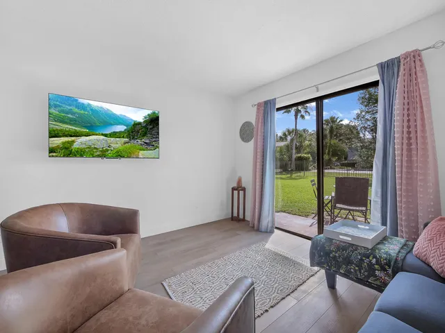 a living room with furniture and a floor to ceiling window