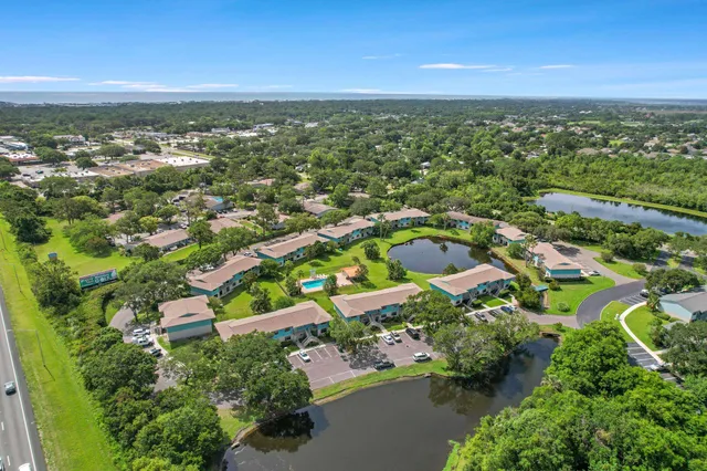 an aerial view of residential houses with outdoor space and trees