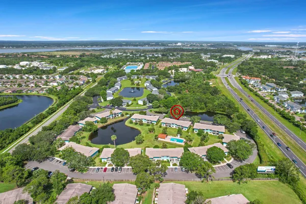 an aerial view of residential houses with outdoor space and trees