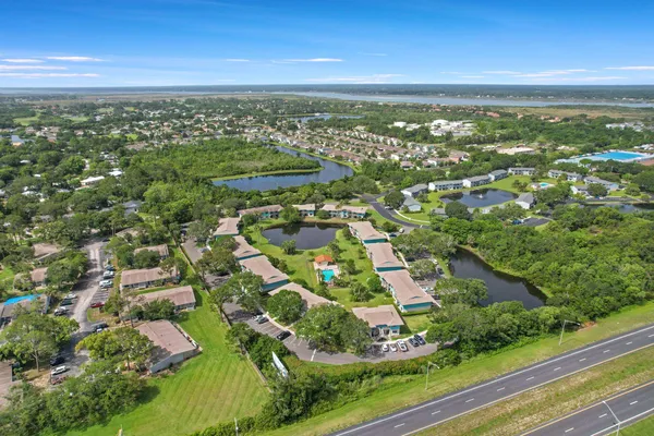 an aerial view of residential houses with outdoor space and trees