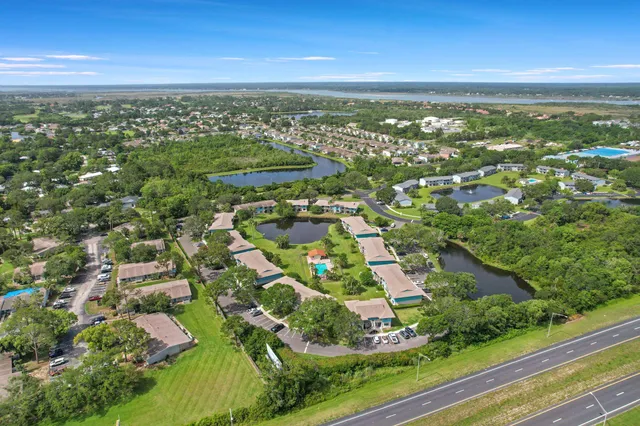 an aerial view of residential houses with outdoor space and trees