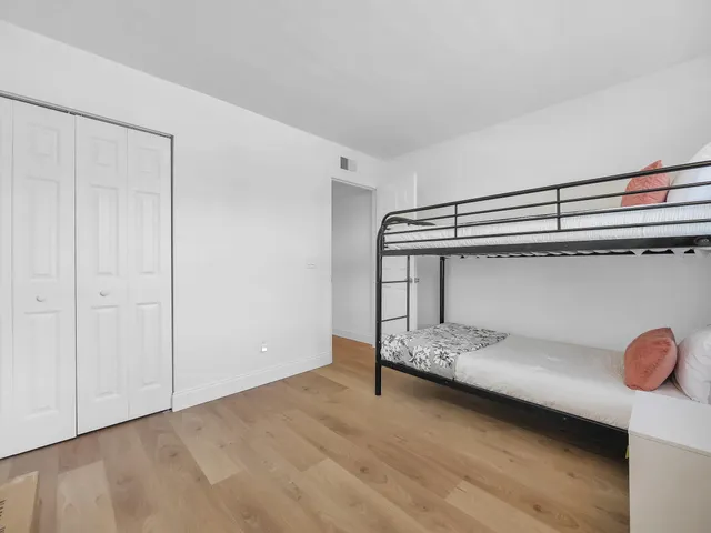 a bedroom with a bed mirror and window
