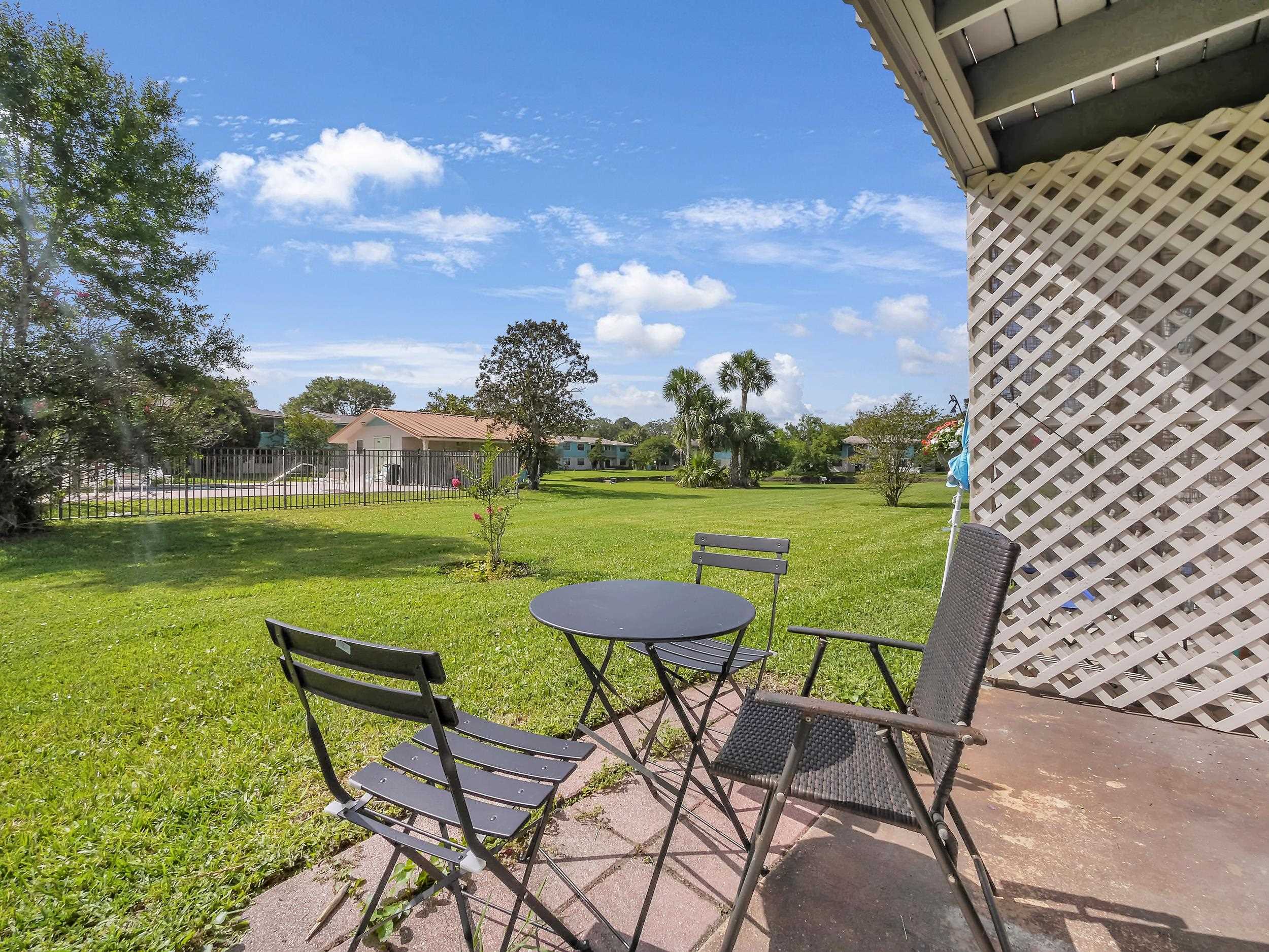 650 West Pope Road, Unit 265 St. Augustine, FL 32080 - Photo 27 of 32 a view of a chairs and table in patio with a lake view