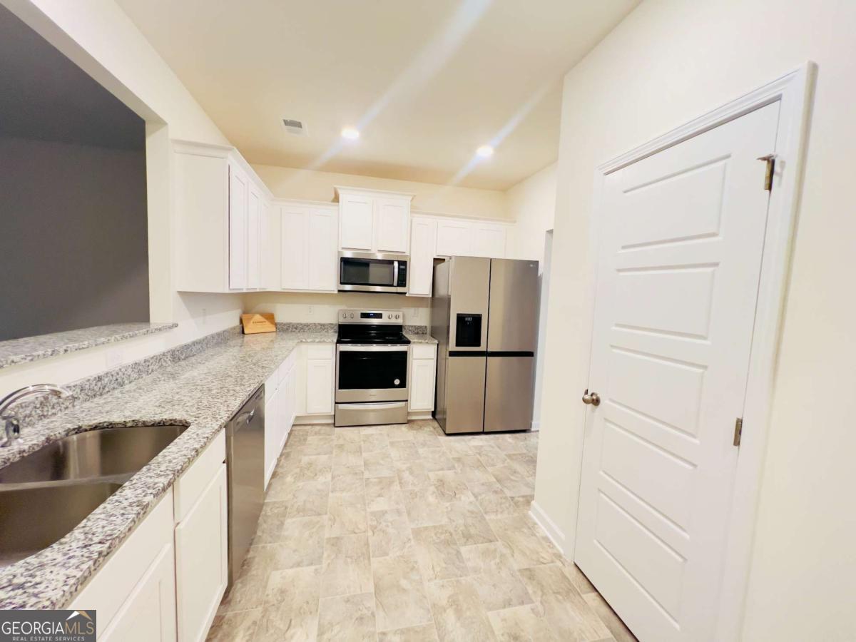 2678 Paxton Place Decatur, GA 30034 - Photo 6 of 22 a kitchen with kitchen island granite countertop cabinets and refrigerator