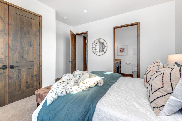 1282 Chimney Rock Road, Unit 344 Heber City, UT 84032 - Photo 41 of 55 Bedroom featuring two-panel solid wood doors with black hardware, recessed lighting, and access to a full bathroom with a toilet and vanity