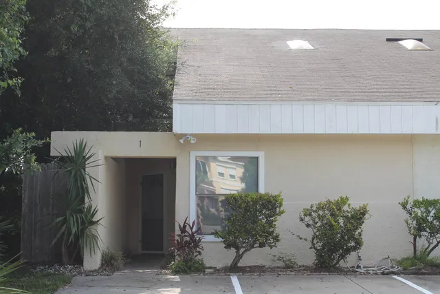 a front view of a house with plants