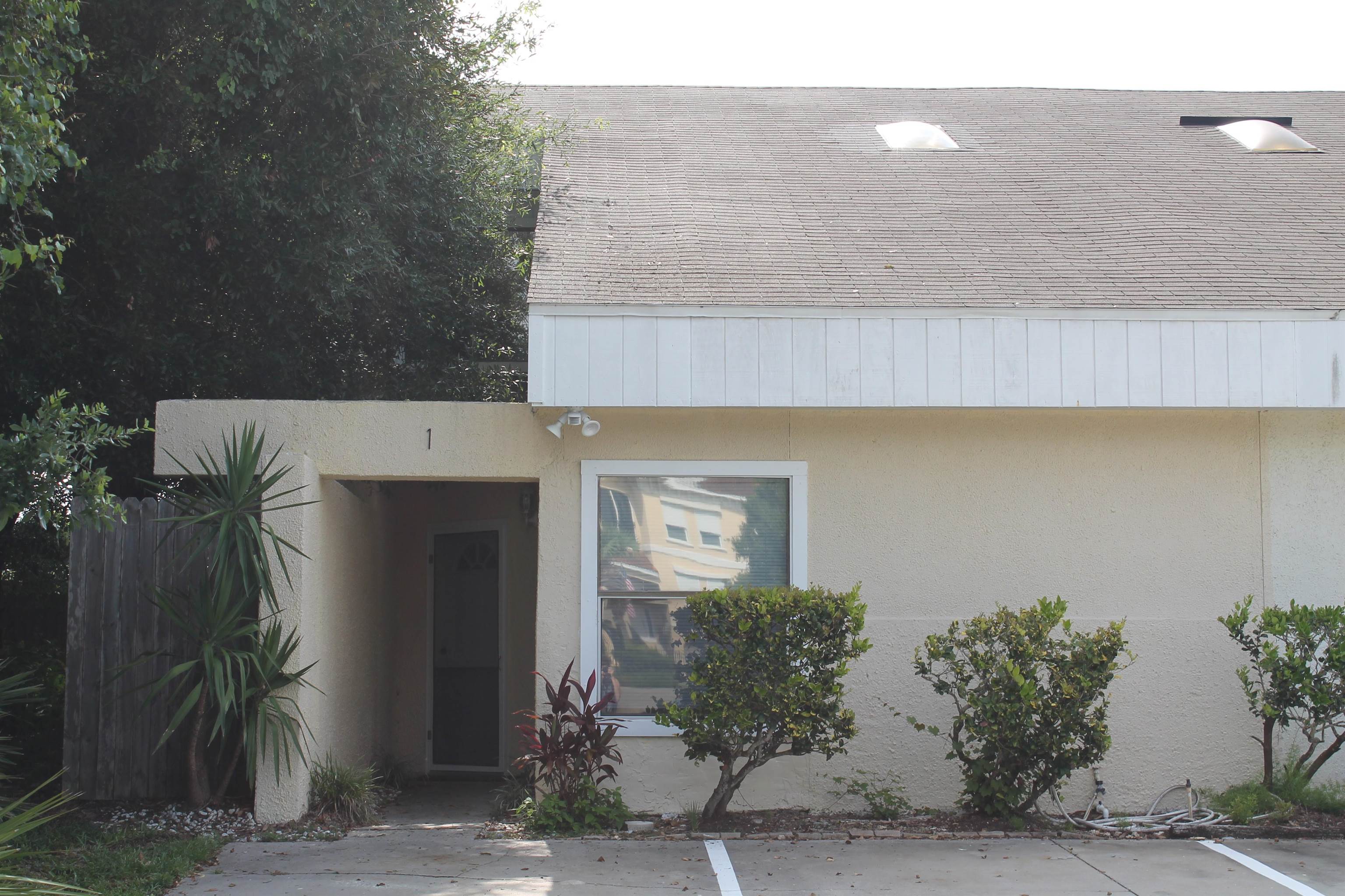 a front view of a house with plants