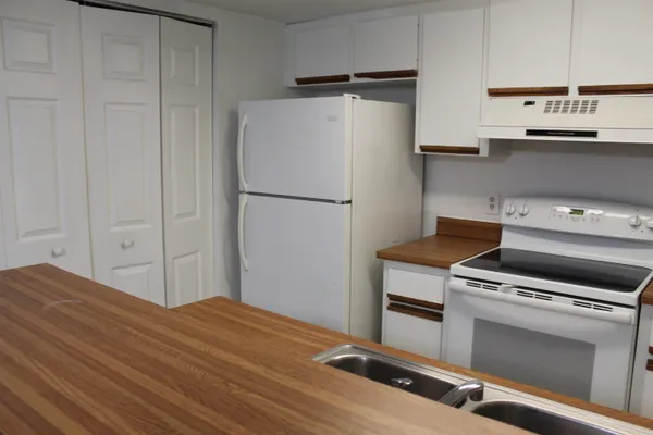 a kitchen with a refrigerator and a stove top oven