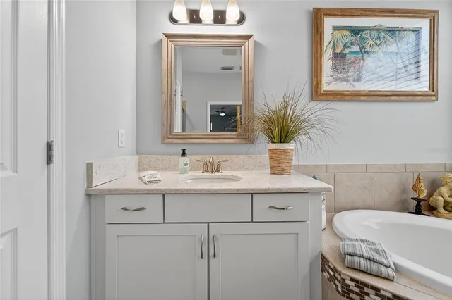 a bathroom with a granite countertop sink vanity mirror and toilet