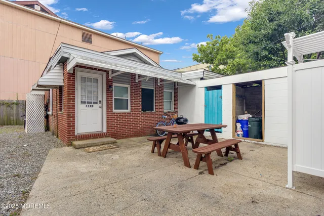 a view of a white house with table and chairs