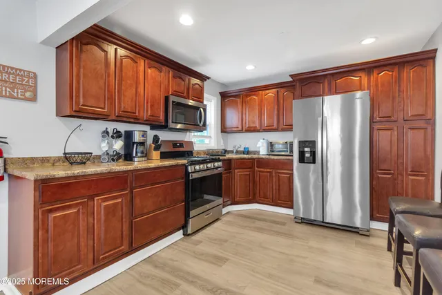 a kitchen with stainless steel appliances granite countertop a refrigerator stove top oven and sink