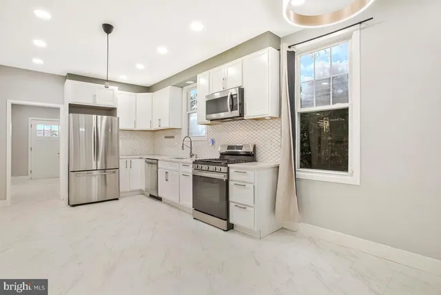 a kitchen with appliances a sink cabinets and a counter top space