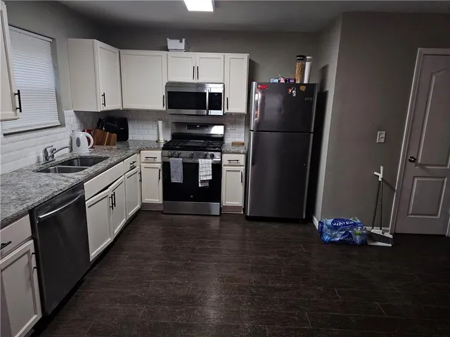 a kitchen with a sink appliances and cabinets