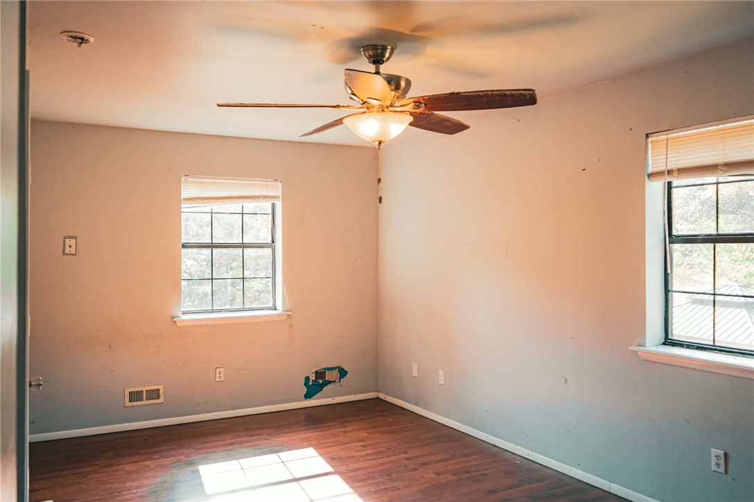 1014 Excelsior Road Greenwood, AR 72936 - Photo 31 of 37 Room with wood-finish flooring, two large windows, a ceiling fan with integrated lighting, and painted walls