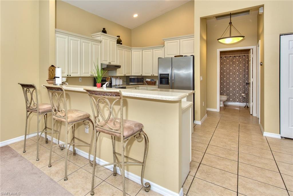 3748 Kent Drive Naples, FL 34112 - Photo 13 of 30 a kitchen with stainless steel appliances a refrigerator and cabinets