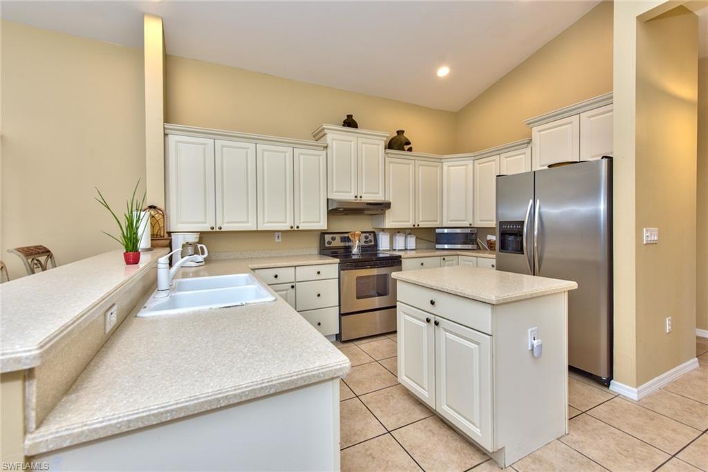 3748 Kent Drive Naples, FL 34112 - Photo 14 of 30 a kitchen with white cabinets and stainless steel appliances