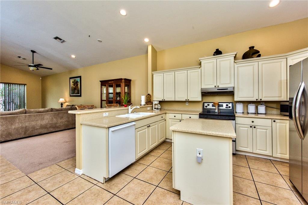 3748 Kent Drive Naples, FL 34112 - Photo 15 of 30 a kitchen with stainless steel appliances granite countertop a stove top oven a sink a counter top space and cabinets