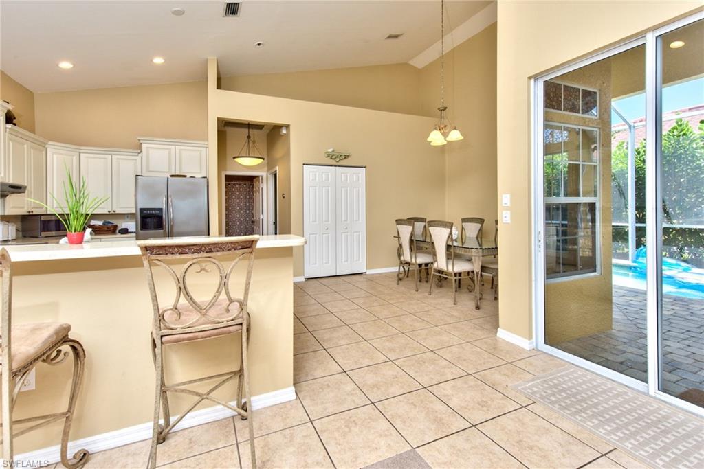 3748 Kent Drive Naples, FL 34112 - Photo 16 of 30 a kitchen with stainless steel appliances kitchen island granite countertop a refrigerator and cabinets