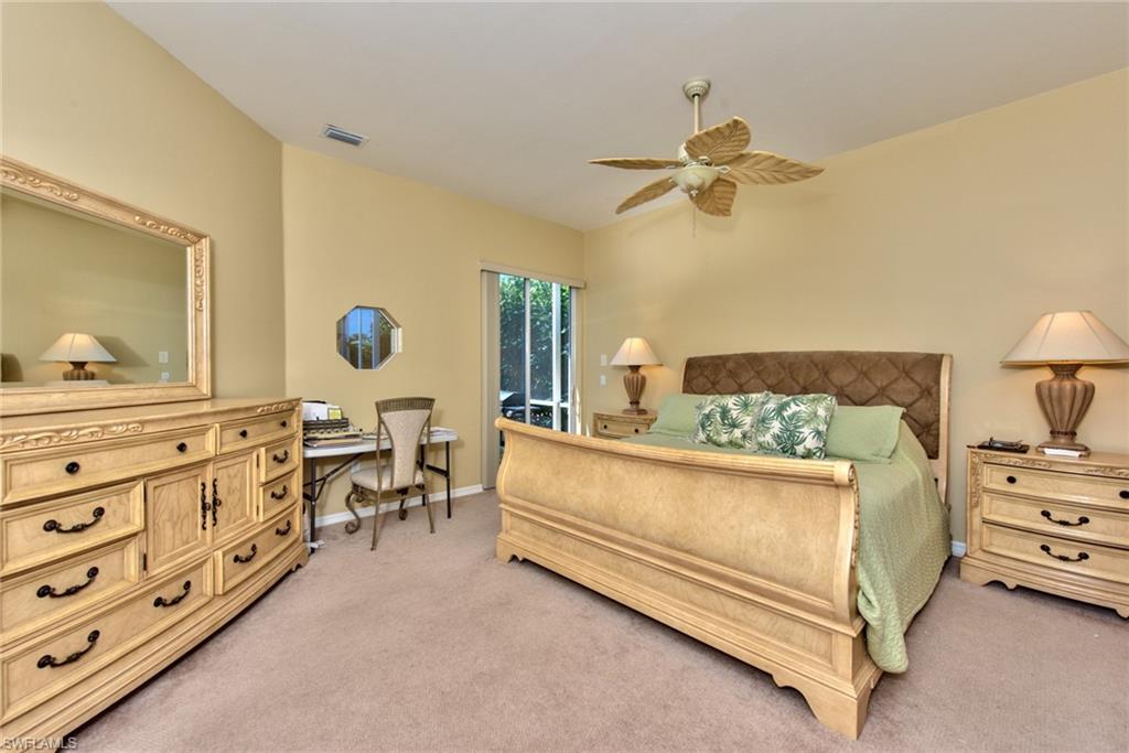 3748 Kent Drive Naples, FL 34112 - Photo 22 of 30 a bedroom with a bed a chandelier and dresser