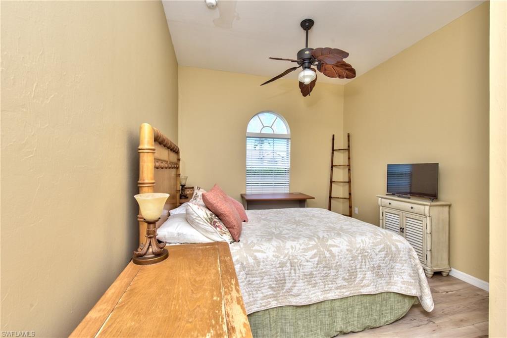3748 Kent Drive Naples, FL 34112 - Photo 30 of 30 a bedroom with a bed and a chandelier