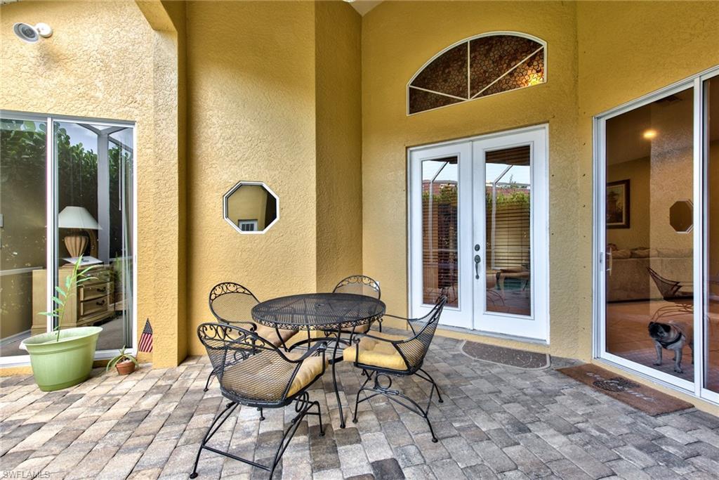 3748 Kent Drive Naples, FL 34112 - Photo 6 of 30 a patio with table and chairs and potted plants